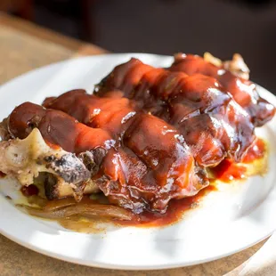 a plate of ribs covered in bbq sauce