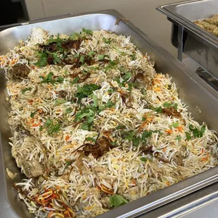 a tray of rice with meat and vegetables