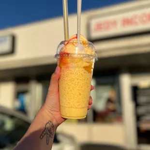 a hand holding a cup of ice cream