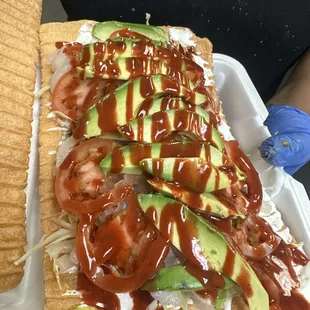 a sandwich with avocado and tomatoes