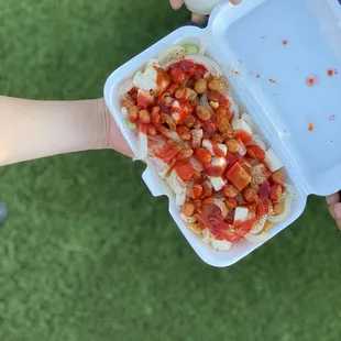 a person holding a container of food