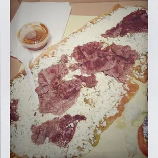 a piece of pizza with meat on it