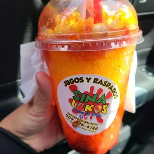 a hand holding a cup of raspberry slush