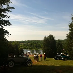 a group of people standing around a vintage car