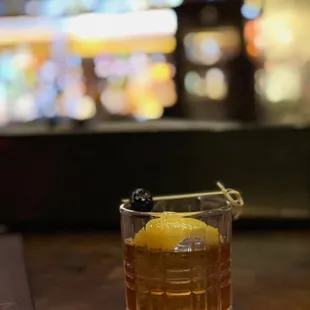 a glass of whiskey with a garnish