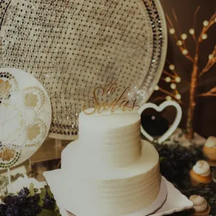 a white wedding cake and cupcakes
