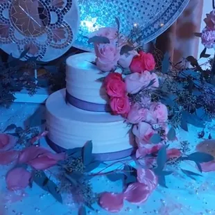 a white wedding cake with pink roses