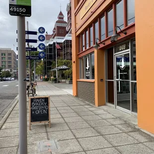 Sign in the sidewalk to the left, entrance to the right.