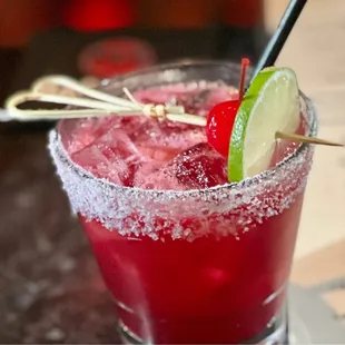 a cocktail with a lime garnish