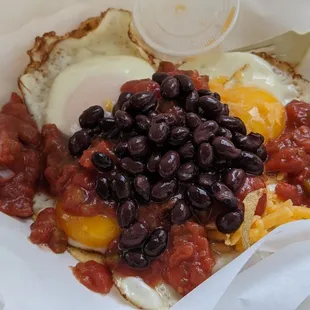 Huevos rancheros after I poured salsa, black beans, and shredded cheese on top of the tortillas and eggs