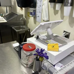 a kitchen counter with a scale and a flower