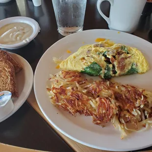 Bacon, spinach, and cheese omelet with hasbrowns, toast, and a side of gravy.