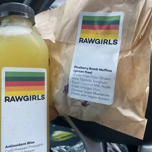 a hand holding a bottle of raw girls juice