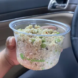 a hand holding a bowl of food