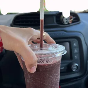 a hand holding a smoothie