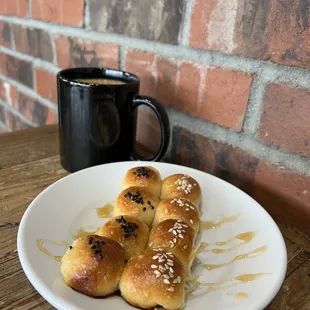 a plate of buns and a cup of coffee