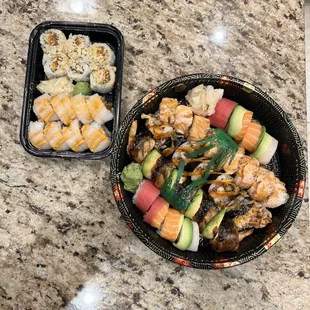 a bowl of sushi and a container of shrimp