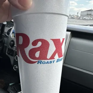 a hand holding a paper cup