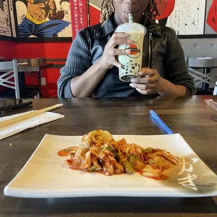 a woman sitting at a table with a plate of food