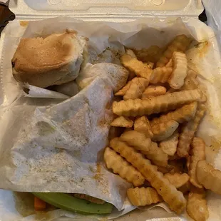 ows a sandwich and fries in a styrofoam container
