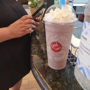 a woman standing at a counter with a drink