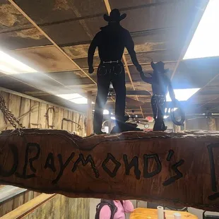 a cowboy standing on a log