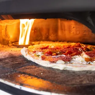 a pizza cooking in an oven