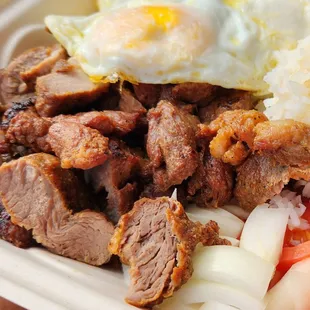 Fried Pork with tomatoes and onions with side order of eggs.
