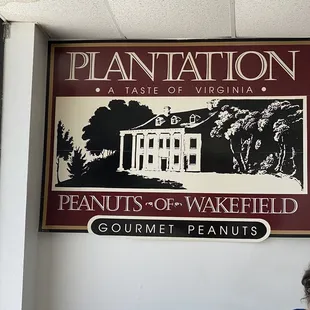 a woman sitting in front of a sign