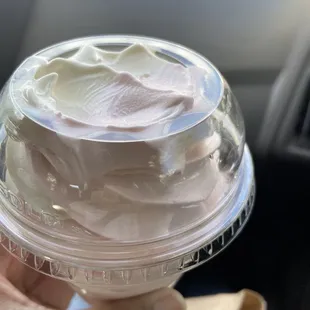 a hand holding a cup of ice cream