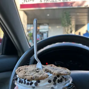 a hand holding a cup of ice cream
