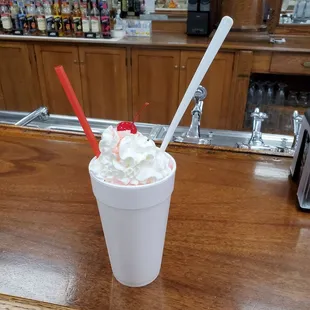a milkshake with whipped cream and a cherry on top