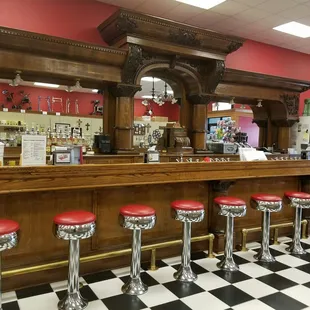 a checkered floor with red stools