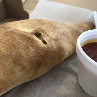 a piece of bread and a cup of sauce