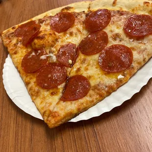 a slice of pepperoni pizza on a paper plate