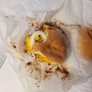 a half eaten hamburger and half an egg