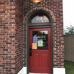 a brick building with a red door