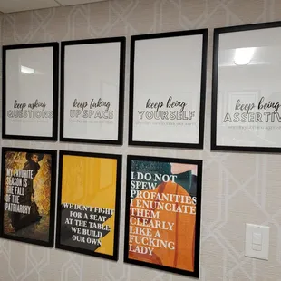 a wall of framed posters