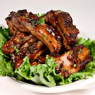a plate of ribs and lettuce