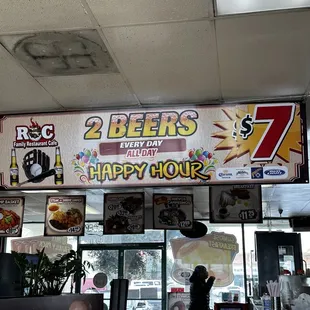 a man standing in front of a happy hour sign