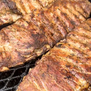 steaks cooking on a grill