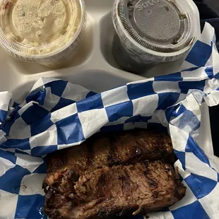 Two pieces of brisket, collard greens and potatoes salad