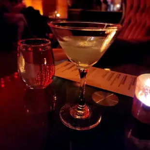 a martini and a candle on a table