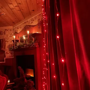 a living room with a fireplace and christmas lights