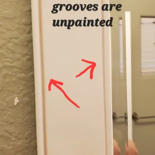 a bathroom mirror with a red arrow pointing to the mirror