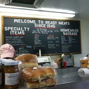 a counter with buns and jars of food