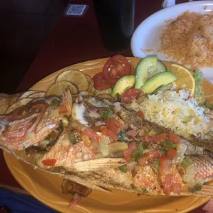 Fried whole red snapper smothered with pepper and onions. Served with rice, potatoes, fruit, and veggies.