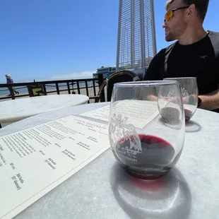 a man sitting at a table with a glass of wine