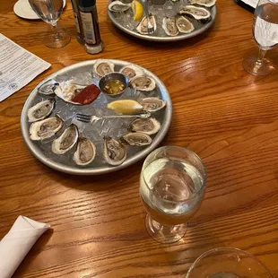 a plate of oysters on a wooden table