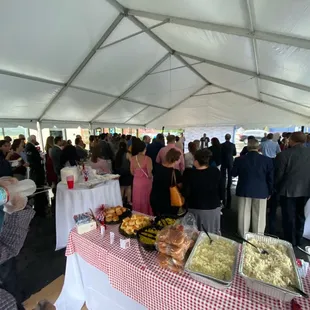 a large group of people standing under a tent